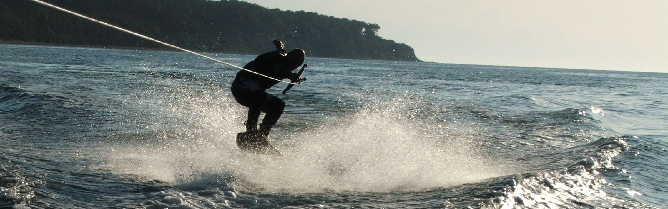 Wakeboard vor dem Küstenwald
